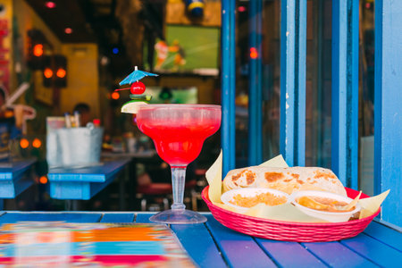 Colorful cocktail in a beautiful glass on a cafe table outdoors on a bright sunny day in  Californiaの写真素材