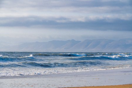 Blue sea, mountains in silhouette, and cloudy sky. Beautiful seascape, tranquil sceneの写真素材