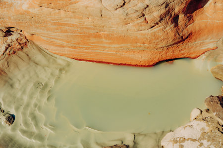 Water hole in rocks and mud in desert after rain seasonの写真素材