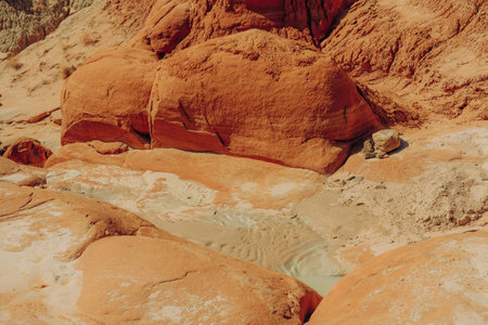Water hole in rocks and mud in desert after rain seasonの写真素材