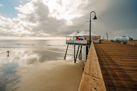Pismo Beach, California - December 6, 2022.  Pismo beach during ISA World Para Surfing Championship. Long wooden pier, sandy beach, and ocean view.のeditorial素材