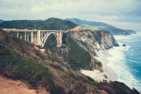 Big Sur, California. Historic Bixby Bridge, rocky coastline, ocean view, and cloudy sky in backgroundの写真素材