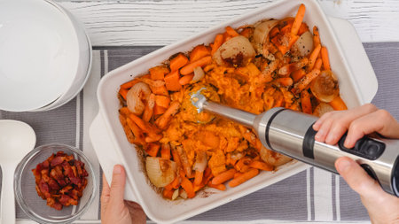 Roasted butternut squash soup recipe, preparation process. Roasted vegetables in a ceramic baking dish, close-up viewの写真素材