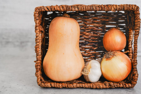 Butternut squash, galic, and onion in a basket, close-up view with copy spaceの写真素材