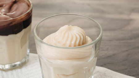 White chocolate vanilla bean pudding in a glass on a wooden table