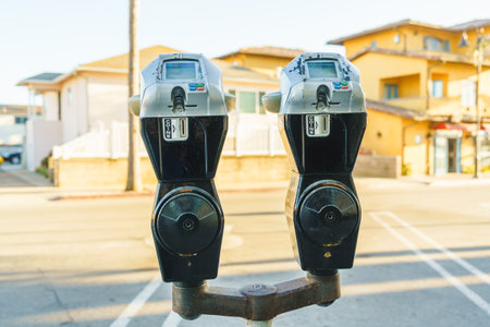 Automated public car parking pay machines and ticket dispensers on the street in a sunny day, with...