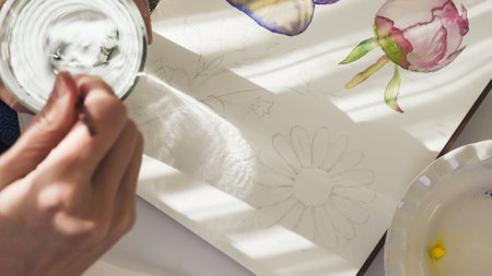 Watercolor painting. Woman draws watercolor sketches, close-up view from aboveの写真素材