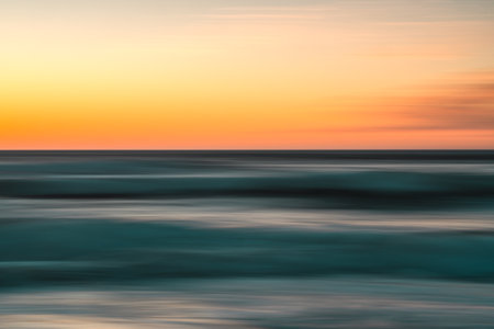 Creative abstract background. Sea and sky at sunset, motion blur, copy spaceの写真素材
