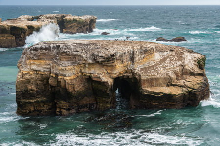 The rugged beauty of a rocky coastline meeting the vast expanse of the ocean under a dramatic sky, California Central Coastの写真素材