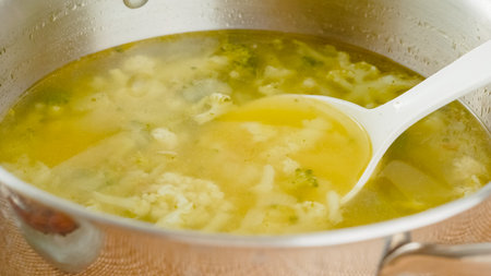 Pot of cauliflower broccoli soup close-up. Delicious homemade vegetarian soup in a cooking potの写真素材