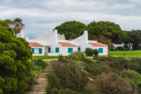Charming white cottages nestled amidst lush green lawns, capturing the essence of a tranquil vacation spot, Algarve, Portugal.の写真素材