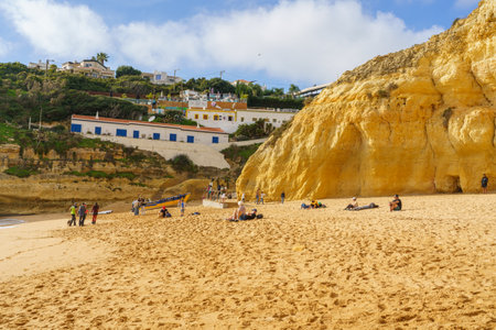 Visitors enjoy a day at the beach beneath the cliffside homes of Algarve. Algarve, Portugal, January 2, 2024.のeditorial素材
