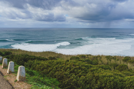 Stormy skies loom over the rugged coastline and rough waves of the Atlantic Ocean.の写真素材