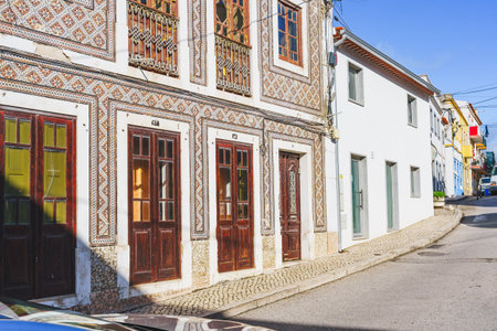 Traditional Portuguese buildings with azulejo tile facades line a street in Nazare, Portugal.の写真素材