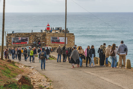 Nazare, Portugal, January 4, 2024. Crowds gather at Nazare's lighthouse to watch the legendary waves and surfers.のeditorial素材