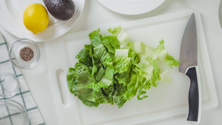 Leaves of fresh green lettuce close-up on white cutting board, flat lay.の写真素材