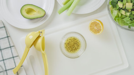 Lemon juice and olive oil salad dressing recipe. Ingredients close-up on white backgroundの写真素材