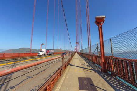 San Francisco, California, April 9, 2024.  Traffic including a large truck moves along the Golden Gate Bridge with pedestrians on the sidewalk.のeditorial素材