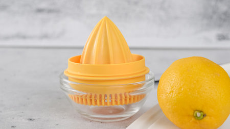 Squizing fresh lemon. Lemon-olive oil salad dressing recipe, ingredients close-upの写真素材