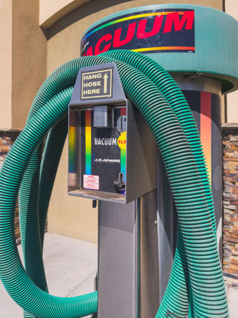 Santa Maria, California, USA - July 21, 2024. Car wash vacuum machine with green hoses and instructional sign.のeditorial素材