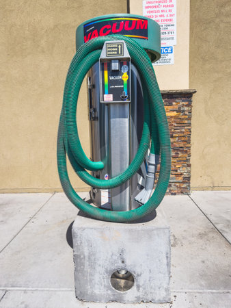 Santa Maria, California, USA - July 21, 2024. Car wash vacuum machine with green hoses and instructional sign.のeditorial素材