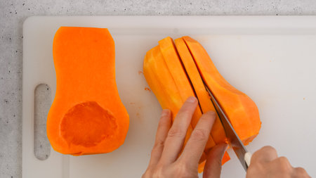 Butternut squash soup recipe. Raw vegetables close-up on the kitchen table. Peeled  and seedless butternut squash close-up on a cutting board, flat layの写真素材