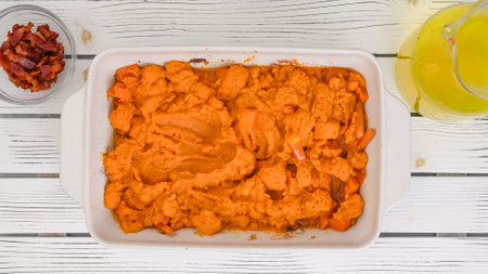 Roasted butternut squash soup recipe, preparation process. Blending roasted vegetables into a puree, adding vegetable stock in a bowl, close-up viewの写真素材