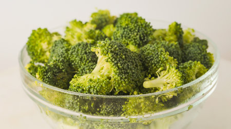 Broccoli florets in a glass bowl close-up on white backgroundの写真素材