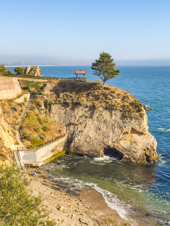 Cliffside gazebo overlooking the ocean with a secluded beach below.の写真素材