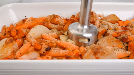 Roasted butternut squash soup recipe, preparation process. Roasted vegetables in a ceramic baking dish, close-up viewの写真素材