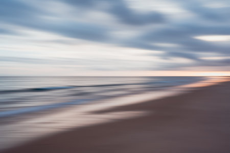Streaks of sunset colors blur across the sky and sea on a swiftly moving beachscapeの写真素材