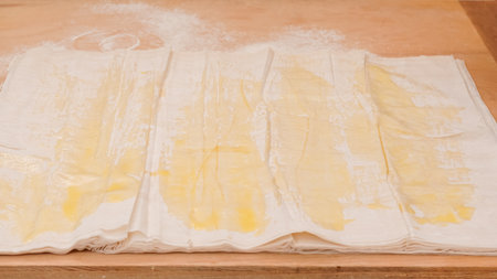 Phyllo dough and melted butter close-up on a wooden background.の写真素材