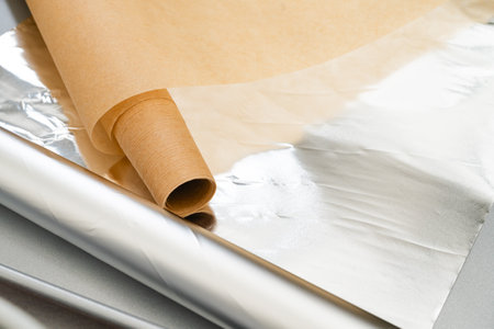Close-up shot capturing the essential baking tools, parchment paper, and aluminum foil, arranged in a visually appealing compositionの写真素材