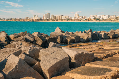 Rocky shoreline with stunning views of the ocean and cityscape.の写真素材