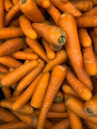 Fresh carrots neatly displayed in a mall container.の写真素材