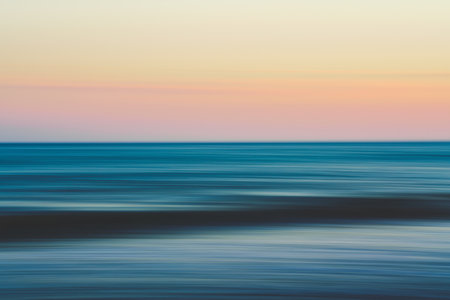 Flowing waves and soft colors blend to create a dreamy seascape.の写真素材