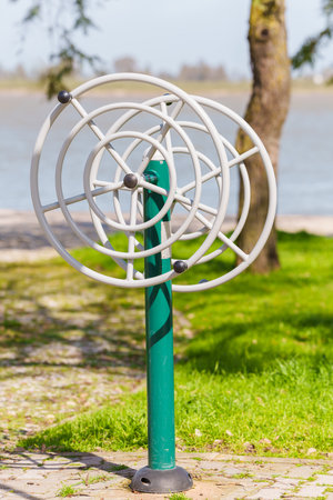 Public exercise machine with rotating wheels designed for upper body workouts in a park.の写真素材