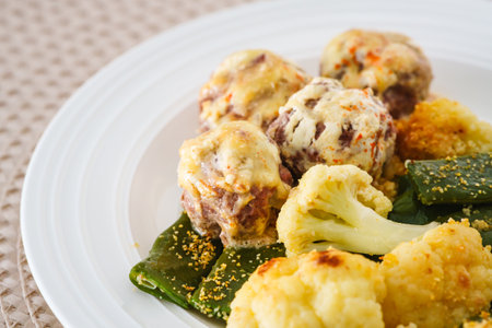 Meatballs, roasted cauliflower, and green beans on a plate.の写真素材