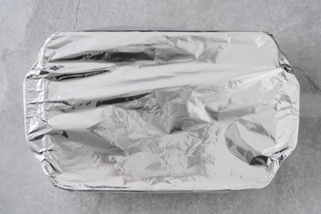 Foil-covered dish ready to go into the oven for baking.の写真素材