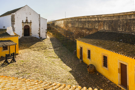 Inside the historic Castle of Castro Marim, a small chapel and rustic buildings evoke the medieval past of Portugal.の写真素材