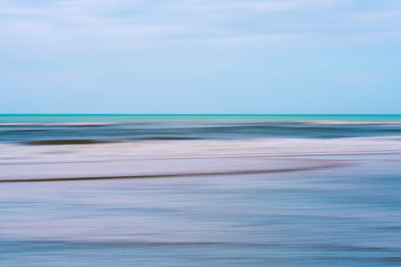 Sea and sky merge in smooth turquoise and pastel tones.の写真素材