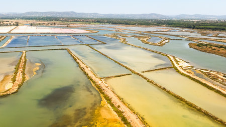 An intricate layout of salt pans and water channels forms a colorful landscape.の写真素材