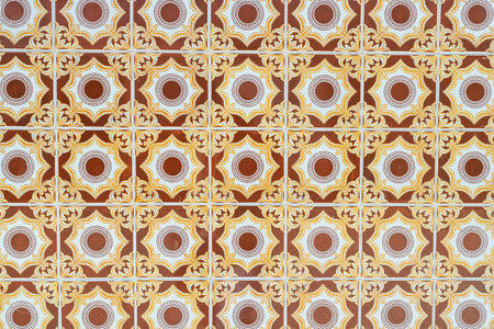 Decorative tiles featuring a repeating circular motif in warm brown, yellow, and white tones.