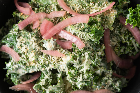 Fresh kale salad topped with pickled red onions, parmesan cheese, and crunchy breadcrumbs.の写真素材