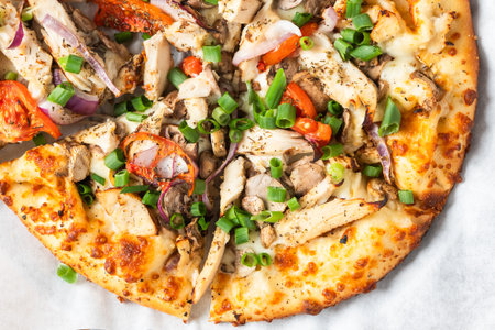 Grilled chicken pizza topped with mushrooms, tomatoes, red onions, and chopped green onions.