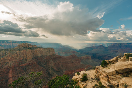 Storm clouds gather over the Grand Canyon, casting shadows across the vast landscape.