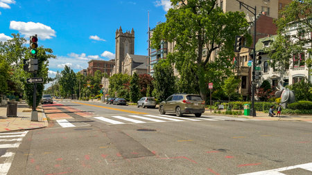 Washington D.C. USA - May 24, 2025. Vehicles drive past a church and various directional signs on a sunny day.のeditorial素材
