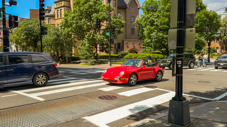 Washington D.C. USA - May 24, 2025. A red convertible Porsche waits at a traffic light near historic buildings and a tree-lined street.のeditorial素材