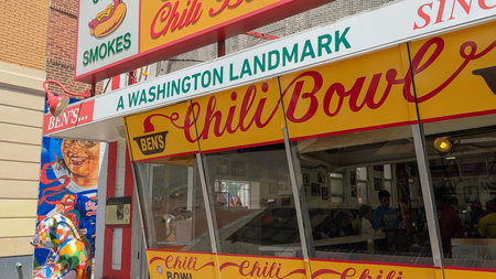 Washington D.C., USA, May 24, 2025. A detailed view of Benâs Chili Bowl shows its bright signage and people dining inside the historic restaurant.のeditorial素材