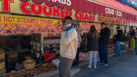 Washington D.C., USA, May 25, 2025. Shoppers line up under red awnings at Jessie Taylor Seafood to...